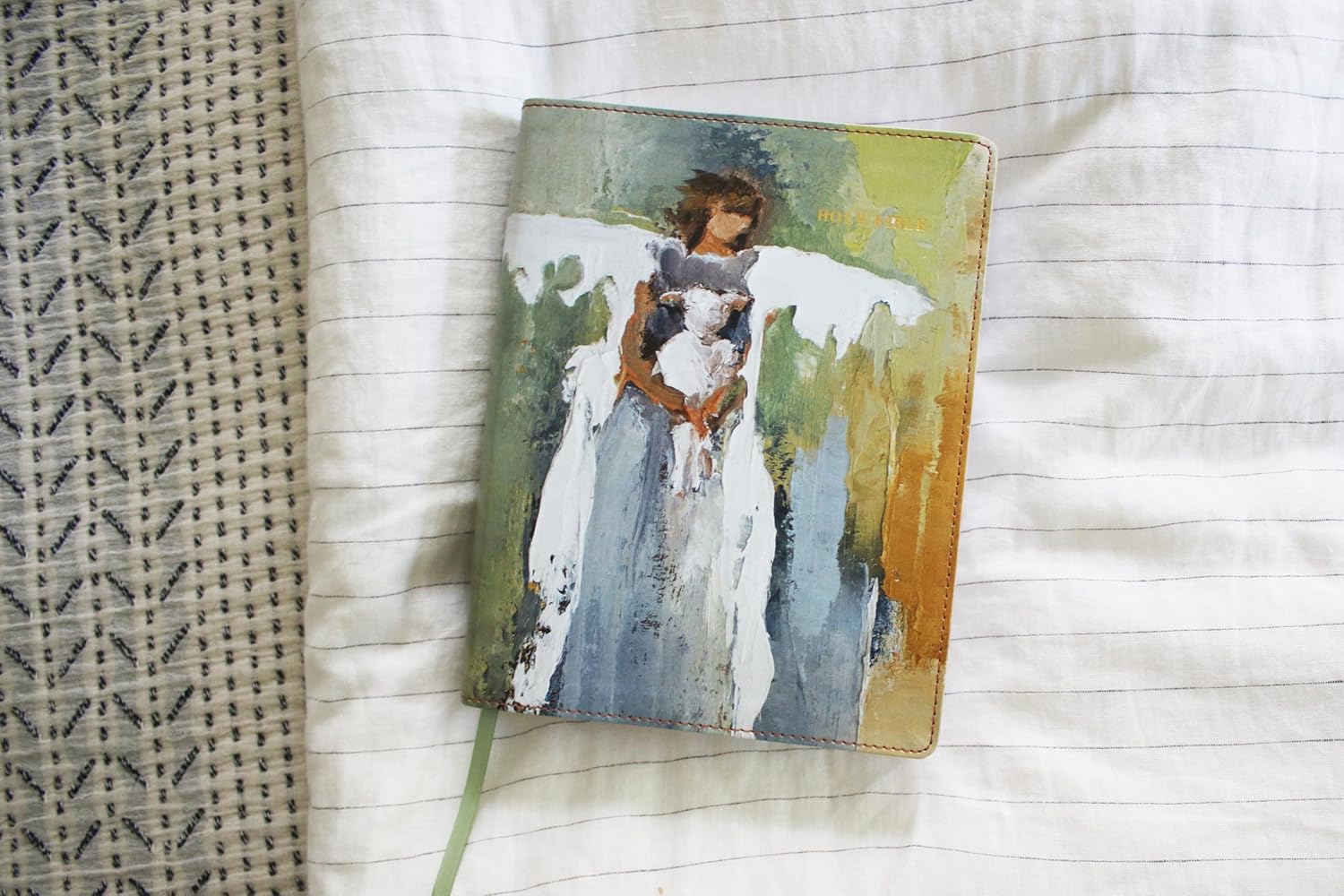 Small painting of an angel holding a child on a textured surface