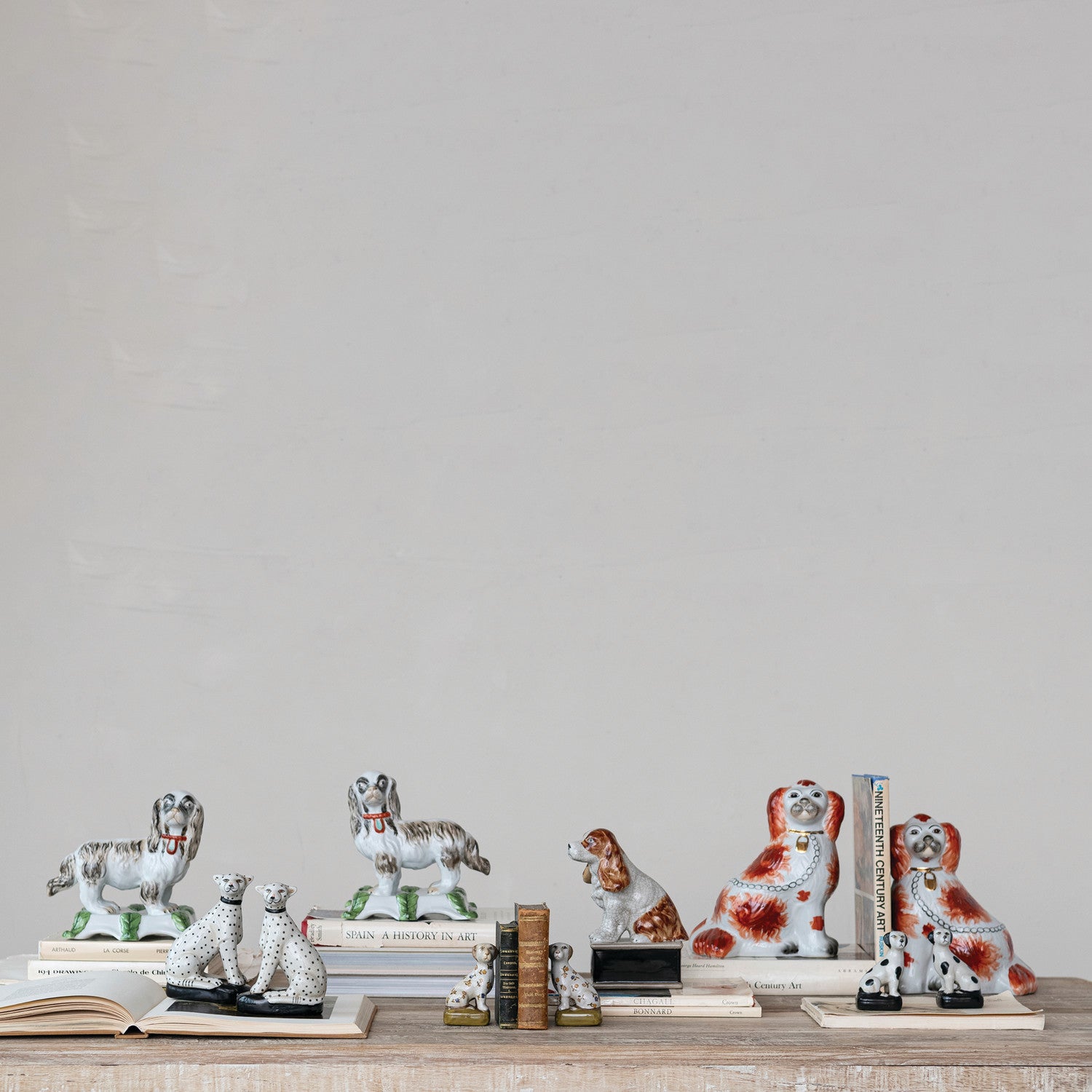 Collection of decorative dog figurines on a shelf against a plain wall.