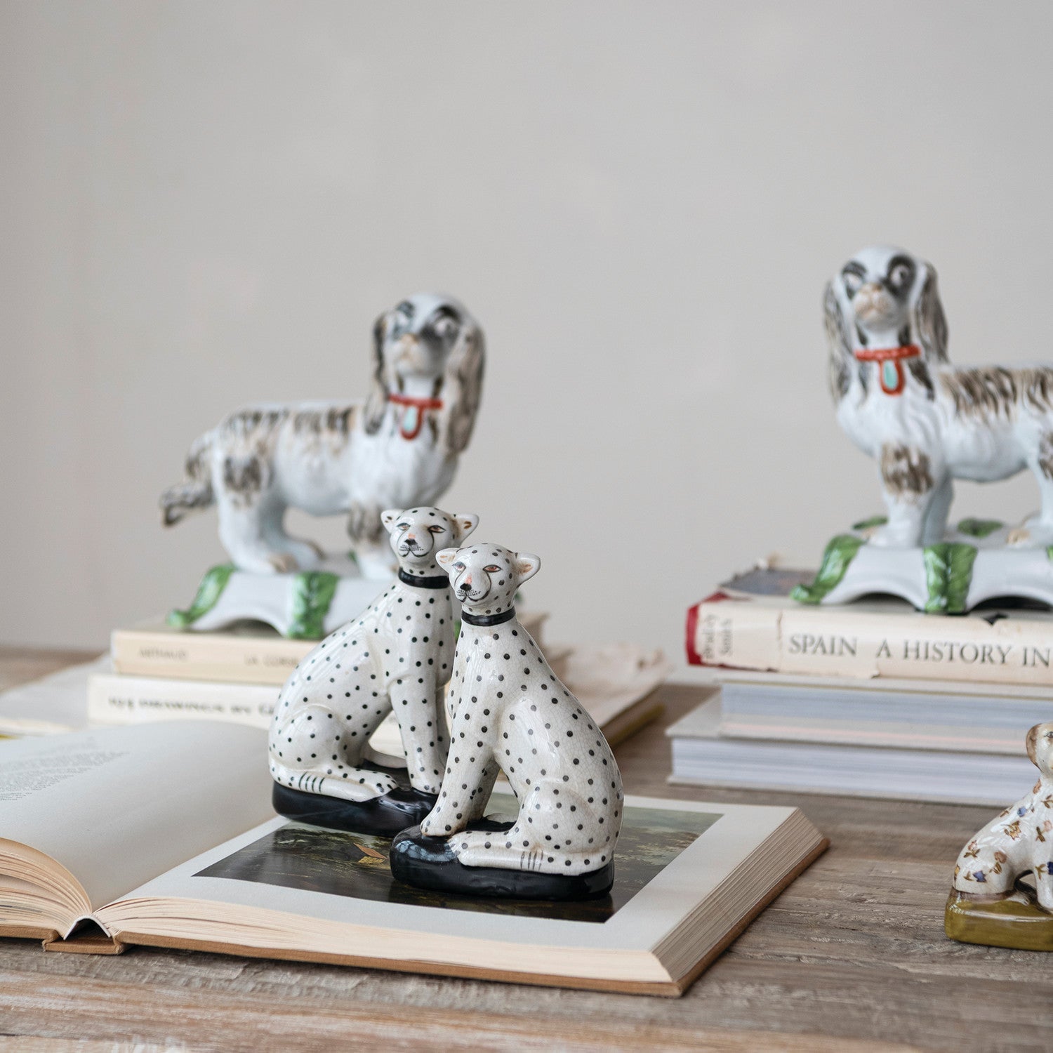 Decorative dog figurines on books with a neutral background