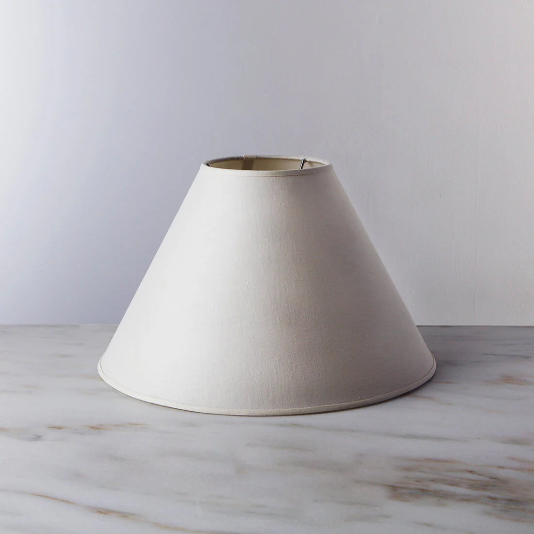 White lampshade on a marble surface with a light gray background