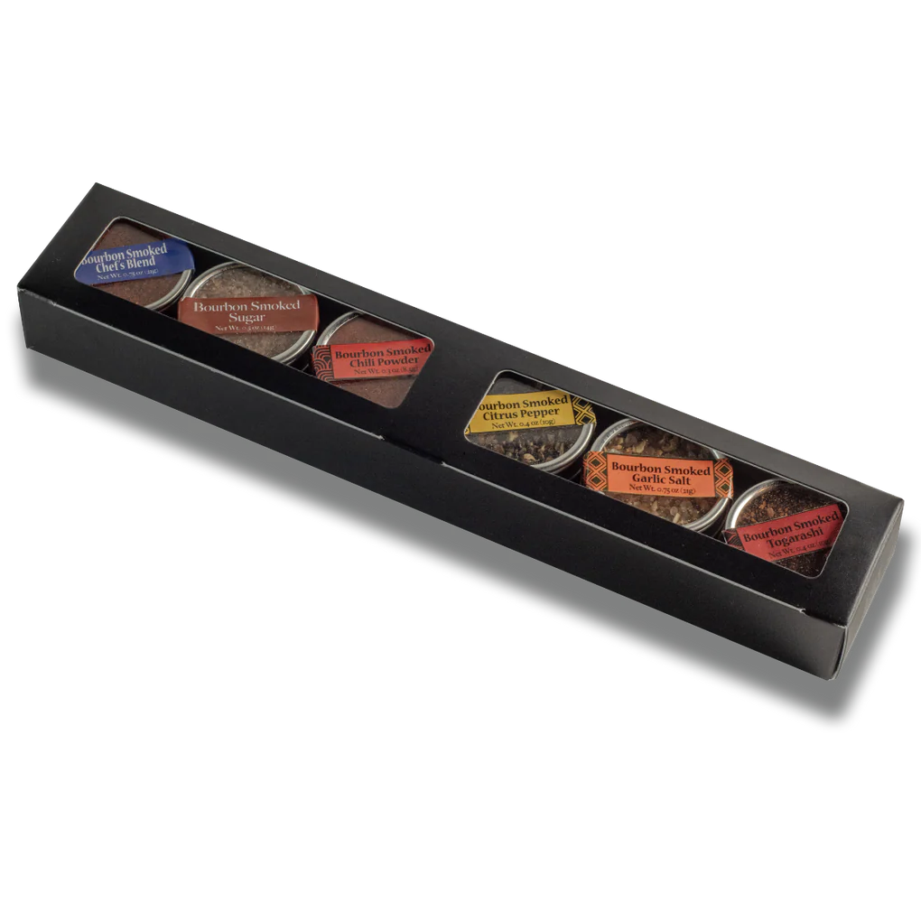 Black box with six different types of spices on a white background