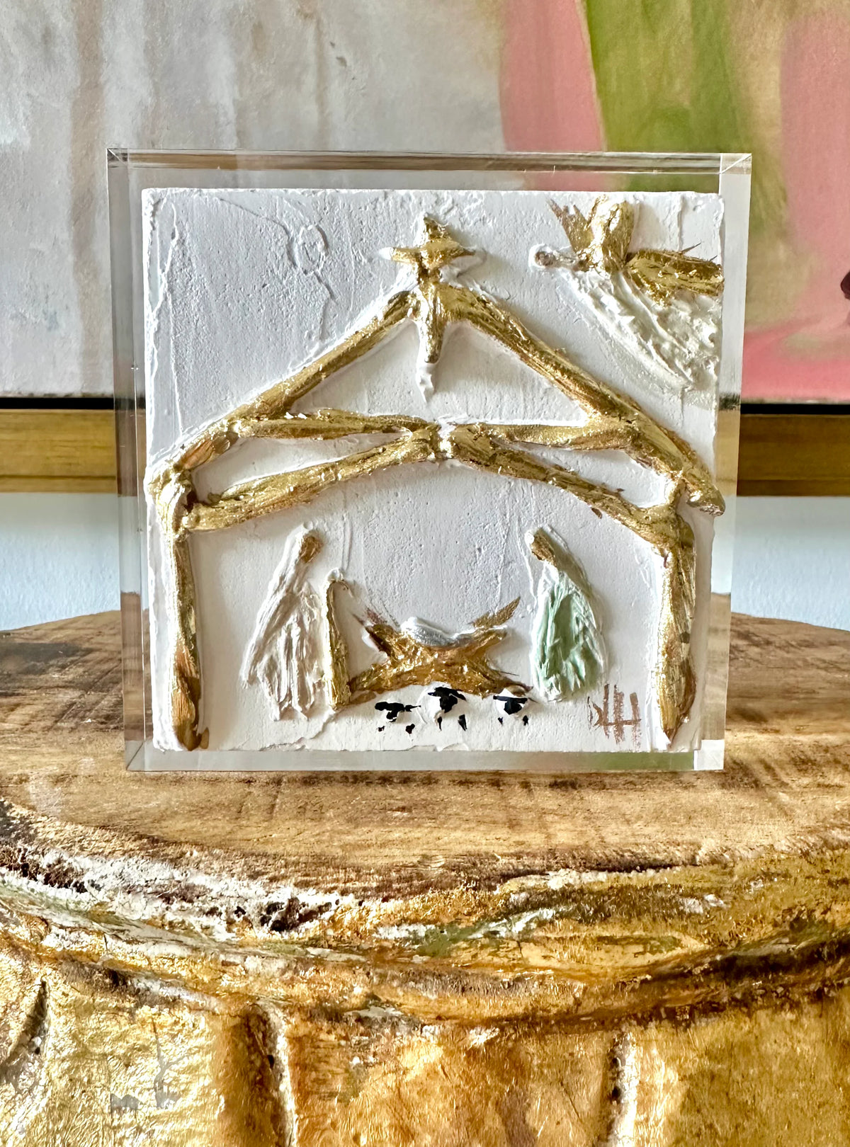 Decorative plaque with a gold house design on a wooden surface