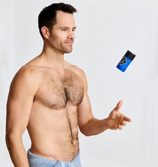 Man pointing to a deodorant stick on a light gray background