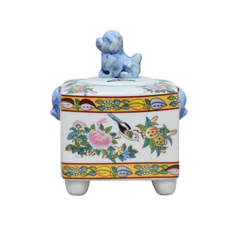 Decorative ceramic box with floral patterns and a small dog figurine on top