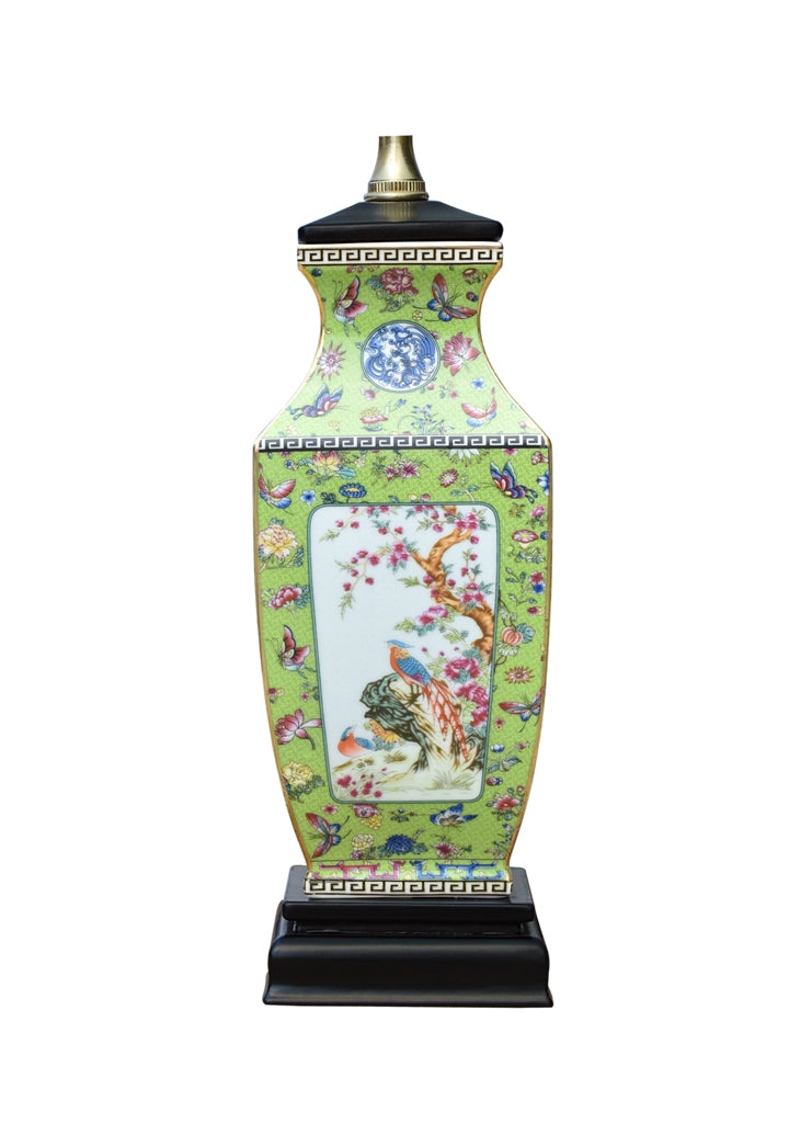 A decorative ceramic table lamp shaped like a vase, featuring a light green body with intricate multicolor floral and bird motifs, a black base, and a gold-toned finial on a white background.