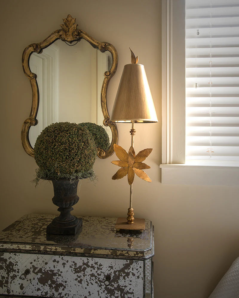 Decorative lamp on a table with a window and mirror in the background