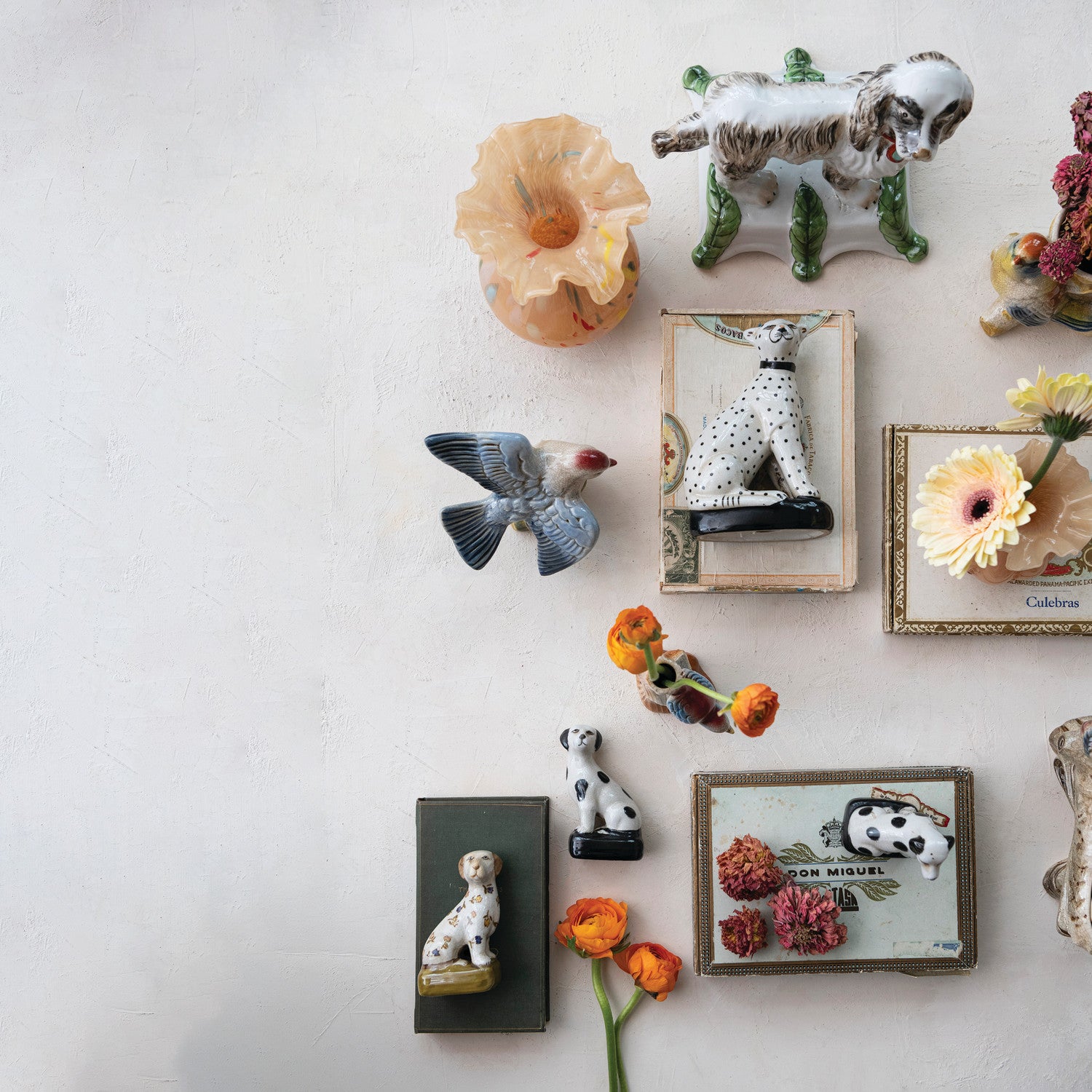 Collection of decorative animal figurines and framed pictures on a white wall.