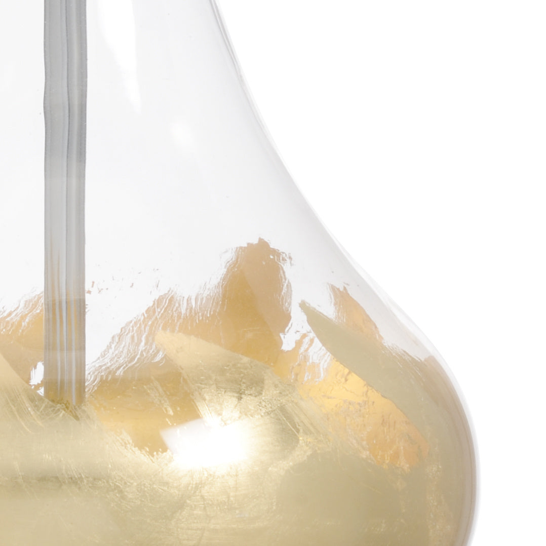Close-up of a modern table lamp with a clear glass shade on a white background