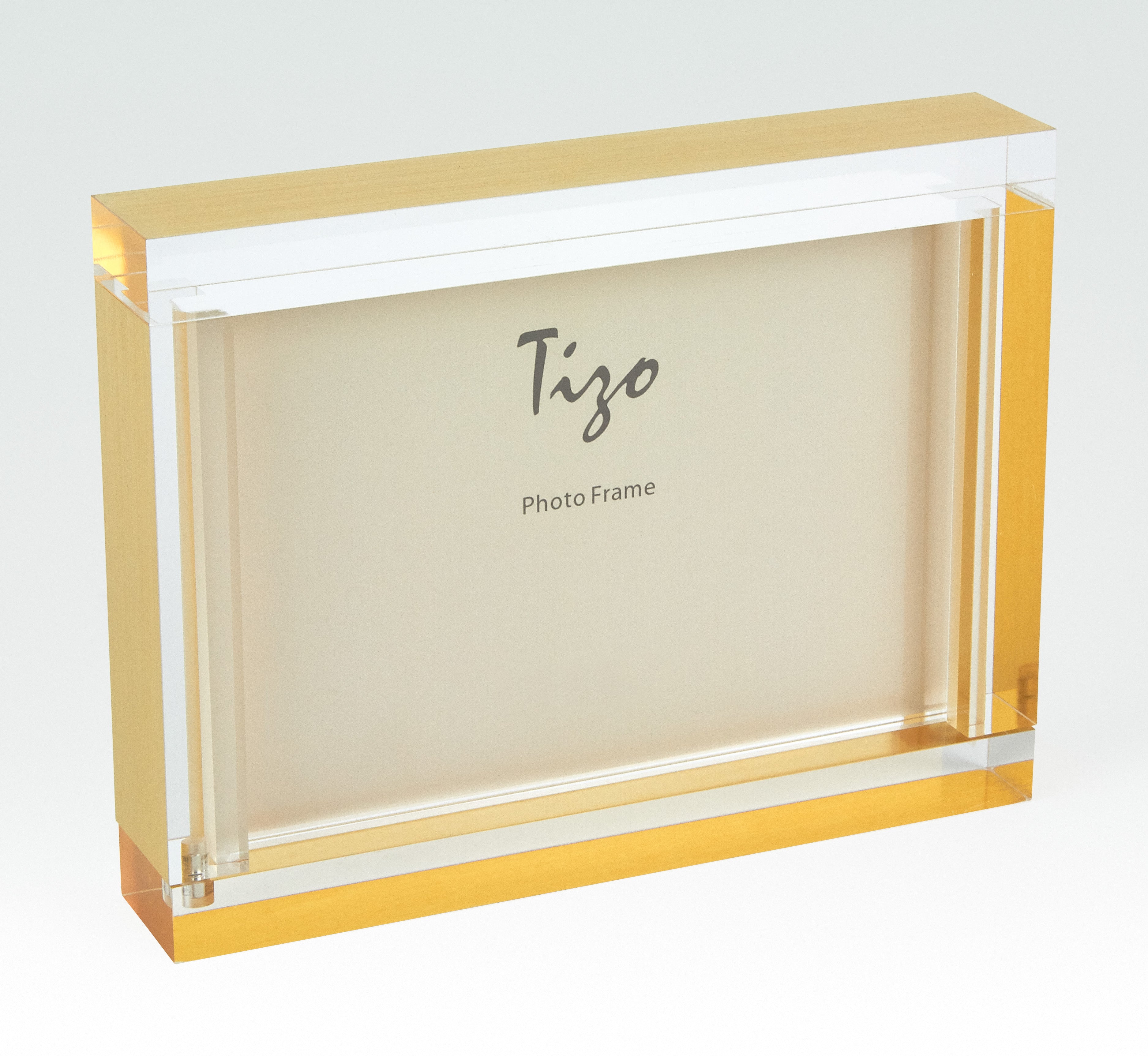 Clear photo frame with gold accents on a white background, featuring the brand 'Tizo'.