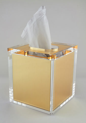 Gold and clear tissue box on a gray background