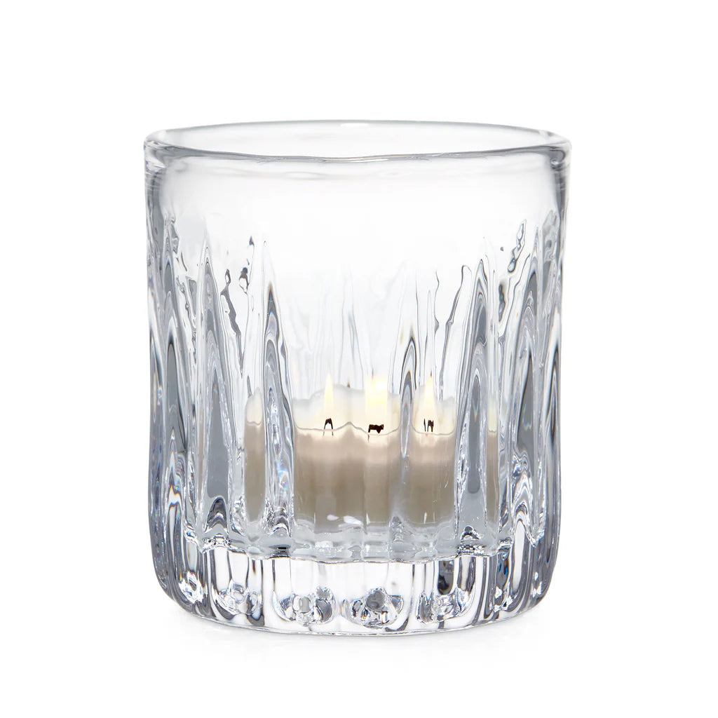 Clear glass candle holder with a candle inside on a white background