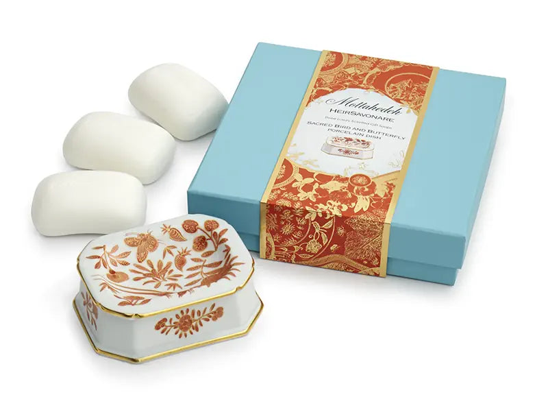Set of soaps with decorative box and floral design on a white background