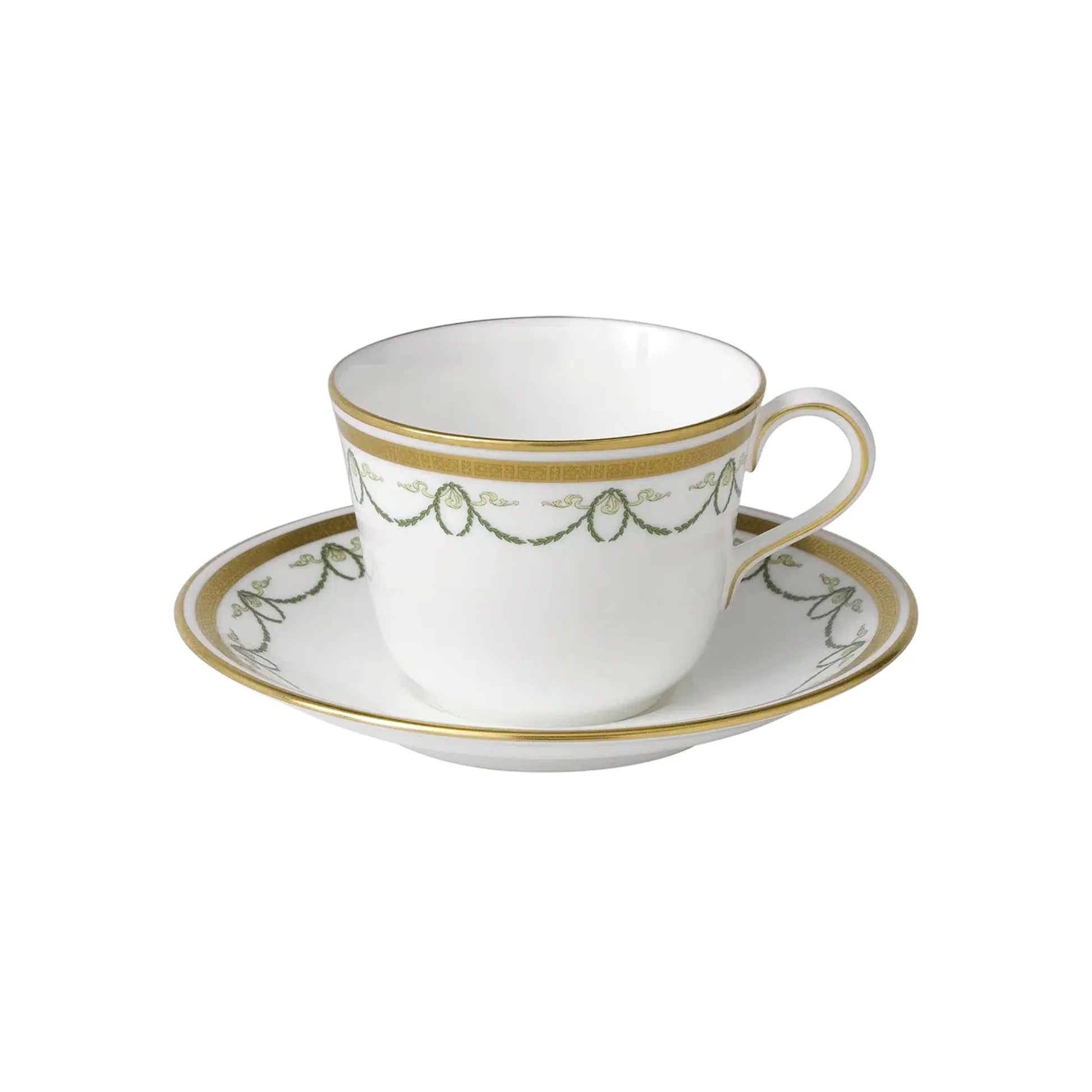 White teacup and saucer with gold and green detailing on a white background